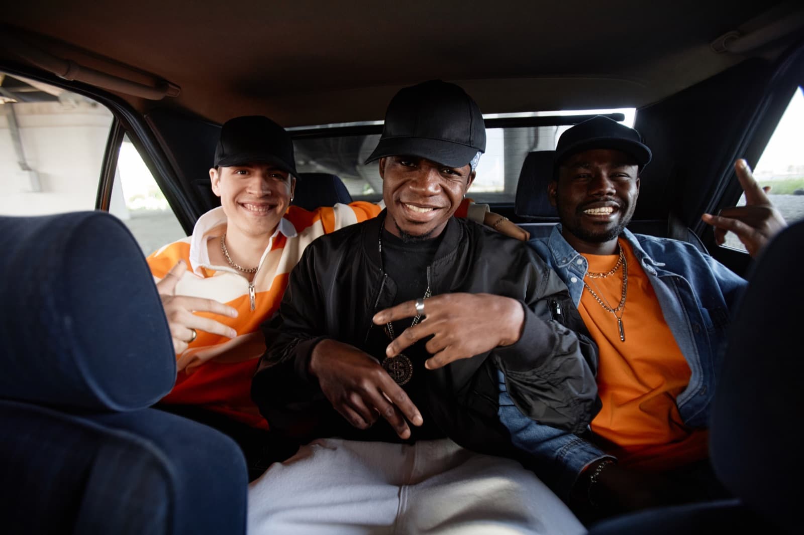Trois passagers souriants installés à l'arrière d'un véhicule lors d'une sortie de groupe